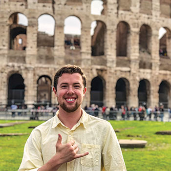 Student standing in front of the Colosseum in Italy.