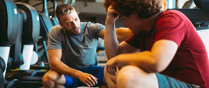 coach talking with athlete in gym