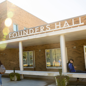 sign with white letters on a brick building reading founders hall