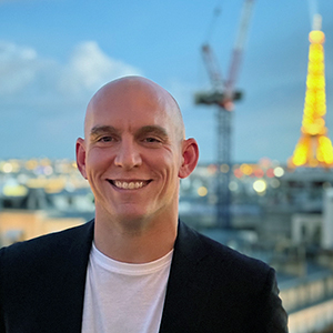 David Prim poses in front of the Paris skyline in spring 2024.