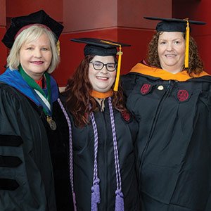 Three women in caps and gowns