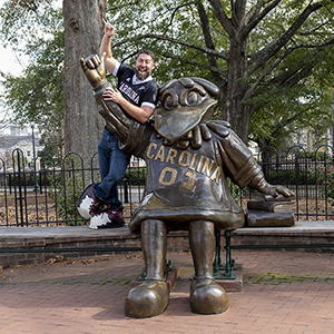 Jamie Ballentine poses with the bronze Cocky statue on USC's campus.