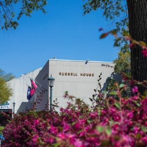 view of Russell House with pink flowers blooming in the foreground