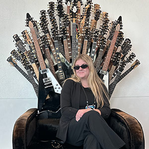 Catherine Pruitt sitting in chair with guitars Catherine Pruitt in chair with guitars